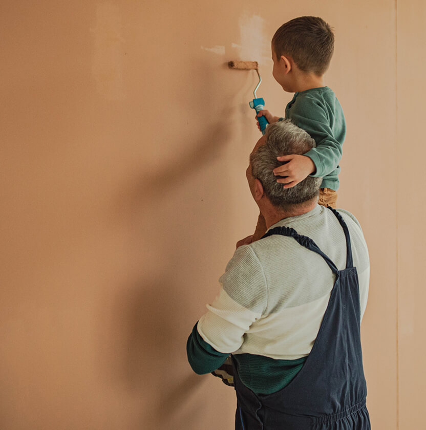 Old man and young child painting wall